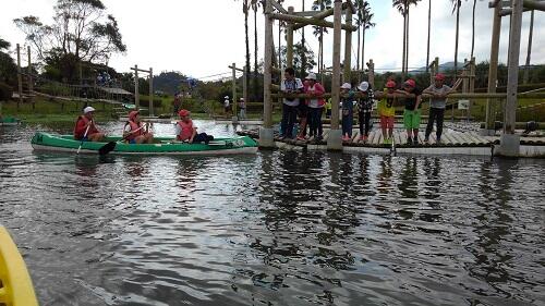 カヌーにのっています。うしろにはアスレチックが写っています。