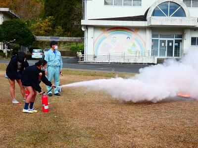 ６年生の代表が火を消しているところです。