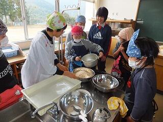 水あめとポンポン菓子を混ぜる児童