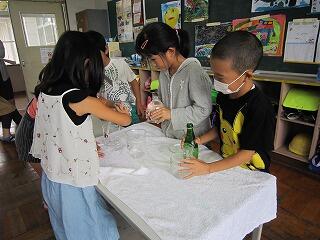 ３つの容器のかさくらべをする１年生。