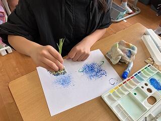 筆を使って絵を描く児童