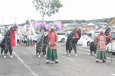 先頭を行く鬼の面と獅子舞