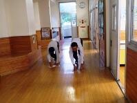 廊下のぞうきんがけをする野球部員