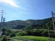 学校の前にある山の斜面と青空