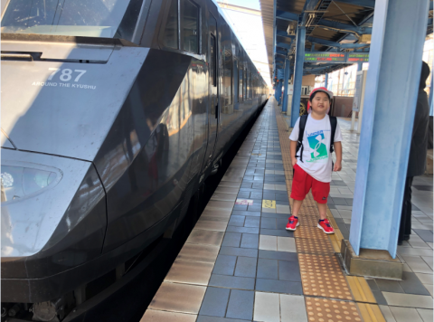 駅のホームで電車の風と音を感じている様子