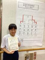 トーナメント表の前で賞状をもって