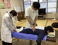 担当教諭に指導を仰ぎながら施術している様子