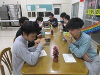 今回は２グループに分かれて行いました。一人リーダーを決めて、グループから自分と同じカードの仲間を探すゲームです。「それは食べ物ですか？」「すっぱいですか？」「調味料としても使われますか？」など周りの人に質問をして仲間を見つけると得点が貰えるルールです。配られたカードを見て、真剣な表情で考えている様子。