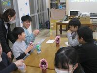 歓談したテーブルには、卒業生の作品（まつぼっくりで作成した桜）がありました。まつぼっくりで、できた桜を触った喜んでいる様子。
