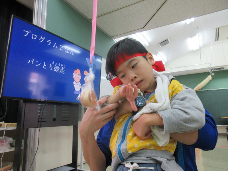 パン取り競争で一生懸命手を伸ばしています