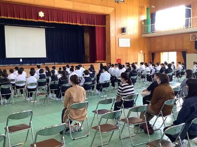 作成した「新聞」を発表した後、校長先生のコメントを聞く１年生