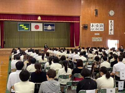 体育館で話を聞く生徒たちと保護者の皆さん