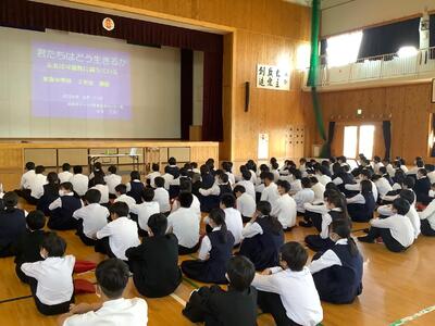 体育館で礼儀正しく講話を聞く生徒たち