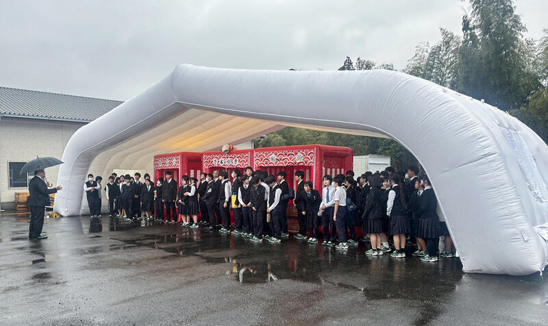 ワン・ステップで巨大な遮光テントを見学する生徒ら＝宮崎市清武町